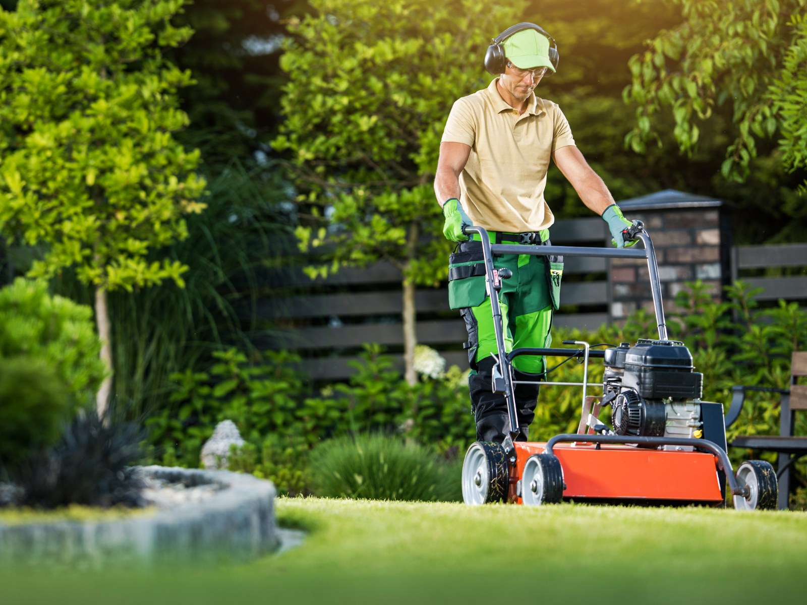 Gartenhelfer schneidet eine grüne Hecke im Freien