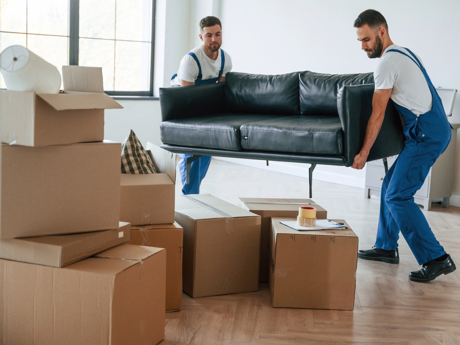 Umzugshelfer trägt Kartons in einem hellen Zuhause